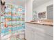 Charming bathroom with kid-friendly shower curtain, playful accessories and a granite countertop vanity at 25106 Quaker Ridge Ave, Sorrento, FL 32776
