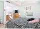 Bedroom leading to bathroom with tv, dresser, and bed with black and white patterned bedding at 2662 Mayaguana St, Kissimmee, FL 34747