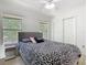 Bedroom with ceiling fan, two windows, closet and bed with black and white patterned bedding at 2662 Mayaguana St, Kissimmee, FL 34747