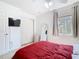 Bright bedroom with white closet, tv, white furniture, red bedspread, and tile floors at 2662 Mayaguana St, Kissimmee, FL 34747