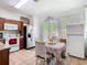 Bright kitchen with tile floors, wood cabinets, white appliances, and an eat-in dining area at 2662 Mayaguana St, Kissimmee, FL 34747