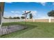 This backyard features a weathered wooden deck and a clothesline, set against a white fence at 269 St Georges Cir, Eagle Lake, FL 33839