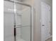 Clean bathroom featuring a glass shower enclosure with built-in shelves and a linen closet nearby at 269 St Georges Cir, Eagle Lake, FL 33839