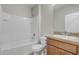 This bathroom features a shower over bath and a wooden vanity with a speckled granite countertop at 269 St Georges Cir, Eagle Lake, FL 33839