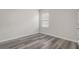 Simple bedroom space with wood-look floors, a window, and neutral walls for versatile decorating options at 269 St Georges Cir, Eagle Lake, FL 33839