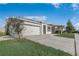 Single-Gathering home with a well-manicured lawn and driveway leading to a two-car garage at 269 St Georges Cir, Eagle Lake, FL 33839
