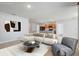 Bright living room featuring a plush sectional sofa, modern art, and an open floor plan connected to the kitchen at 269 St Georges Cir, Eagle Lake, FL 33839
