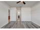 Spacious main bedroom showcasing wood-look flooring, a ceiling fan, and an en-suite bathroom at 269 St Georges Cir, Eagle Lake, FL 33839