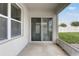 A covered porch with a sliding glass door that provides access to the backyard at 269 St Georges Cir, Eagle Lake, FL 33839