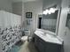 Bright bathroom with a shower-tub combination, white marble countertop, and framed mirror at 2785 Almaton Loop # 204, Kissimmee, FL 34747