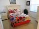 Comfortable bedroom featuring a queen bed with floral bedding, a dresser, and a nightstand with a lamp at 2785 Almaton Loop # 204, Kissimmee, FL 34747
