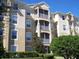 Beige multistory building with screened in balconies and well maintained landscaping at 2785 Almaton Loop # 204, Kissimmee, FL 34747