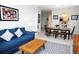 Open living area with a comfortable blue sofa, wooden coffee table, and a view of the dining area and kitchen at 2785 Almaton Loop # 204, Kissimmee, FL 34747