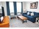 Comfortable living room with a blue sofa, patterned armchairs, a wooden coffee table, and bright, natural light at 2785 Almaton Loop # 204, Kissimmee, FL 34747