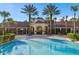 Community pool area with palm trees and clubhouse in the background at 2785 Almaton Loop # 204, Kissimmee, FL 34747