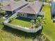 Aerial view of a fenced backyard with lush grass, a patio, and young fruit trees at 280 Caryota Ct, New Smyrna Beach, FL 32168
