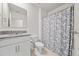 Bathroom features white vanity with granite countertop and a shower with blue curtain at 280 Caryota Ct, New Smyrna Beach, FL 32168