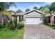 Charming home with a two-car garage, brick driveway, and beautiful landscaping at 280 Caryota Ct, New Smyrna Beach, FL 32168