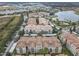 An aerial view of condos is shown with lake view nearby, parking, and beautiful landscaping at 3000 Laurel Park Ln # 202, Kissimmee, FL 34741