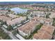 An aerial view captures the lake and community featuring multi-Gathering residences with covered parking and lush landscaping at 3000 Laurel Park Ln # 202, Kissimmee, FL 34741