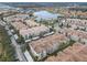 An aerial view captures the lake and community featuring multi-Gathering residences with covered parking and lush landscaping at 3000 Laurel Park Ln # 202, Kissimmee, FL 34741