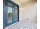 An open air, tiled balcony features blue French doors and a decorative tiled floor at 3000 Laurel Park Ln # 202, Kissimmee, FL 34741