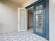 A tiled balcony shows a pair of open blue glass doors leading inside, and the patterned tiles of the patio at 3000 Laurel Park Ln # 202, Kissimmee, FL 34741