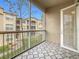 Balcony features tiled floor and screened-in railing overlooking neighboring buildings and landscaping at 3000 Laurel Park Ln # 202, Kissimmee, FL 34741