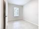 Clean bedroom with neutral paint, white door, tiled floors, and a window at 3000 Laurel Park Ln # 202, Kissimmee, FL 34741