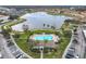 Aerial view featuring a community pool, lake with fountains, surrounded by residential buildings and lush landscaping at 3000 Laurel Park Ln # 202, Kissimmee, FL 34741