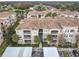 Exterior elevation of a condo building with multiple balconies and covered parking at 3000 Laurel Park Ln # 202, Kissimmee, FL 34741