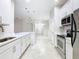 Modern kitchen featuring stainless steel appliances, white cabinets, and sleek countertops with open view of living space at 3000 Laurel Park Ln # 202, Kissimmee, FL 34741