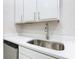 Clean kitchen sink features a stainless faucet and quartz countertops with white cabinets at 3000 Laurel Park Ln # 202, Kissimmee, FL 34741