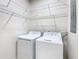 Functional laundry area with washer, dryer, and wire shelving for organized storage solutions at 3000 Laurel Park Ln # 202, Kissimmee, FL 34741