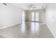 Bright and airy living room with tile floors, neutral walls, ceiling fan and double doors to balcony at 3000 Laurel Park Ln # 202, Kissimmee, FL 34741