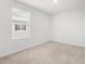 Bright bedroom featuring a large window with blinds and carpeted floor at 3039 Meleto Blvd, New Smyrna Beach, FL 32168