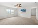 Spacious bedroom with ceiling fan, tv, large window with view, and carpet at 3039 Meleto Blvd, New Smyrna Beach, FL 32168