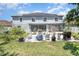 Inviting backyard with patio, seating, grill, lush landscaping, and solar panels on the home's roof at 3063 Mandolin Dr, Kissimmee, FL 34744