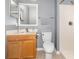 Well-lit bathroom featuring a wooden vanity, white toilet, tiled floors, and a shower with white tile surround at 3063 Mandolin Dr, Kissimmee, FL 34744
