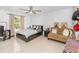 Sunny bedroom offering tile floors, a ceiling fan, and a comfortable sitting area at 3063 Mandolin Dr, Kissimmee, FL 34744