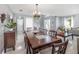 Dining area with modern chandelier, staircase, tile floors, and an elegant table setting for formal dining at 3063 Mandolin Dr, Kissimmee, FL 34744