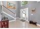 Bright foyer featuring tile flooring, a staircase with white railings, and a decorative wreath on the front door at 3063 Mandolin Dr, Kissimmee, FL 34744