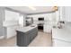 Modern kitchen with white cabinets, stainless steel appliances, gray island, and stylish tile backsplash at 3063 Mandolin Dr, Kissimmee, FL 34744