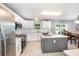 Bright kitchen features stainless appliances, island, and white cabinetry, blending seamlessly with the dining area at 3063 Mandolin Dr, Kissimmee, FL 34744