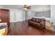 Open floorplan living room with hardwood floors, a brown leather sofa, and large white storage closets at 3063 Mandolin Dr, Kissimmee, FL 34744