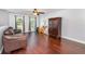 Spacious living room with hardwood floors, arched windows, a ceiling fan, and comfortable brown leather sofa at 3063 Mandolin Dr, Kissimmee, FL 34744