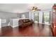 Bright living room boasts hardwood floors, arched windows with curtains, a ceiling fan, and a comfortable sofa at 3063 Mandolin Dr, Kissimmee, FL 34744