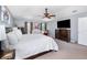 Spacious main bedroom featuring carpeted floors, ceiling fan, comfortable bed and a television on dresser at 3063 Mandolin Dr, Kissimmee, FL 34744