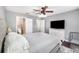 Bright main bedroom with a ceiling fan, white dresser, television and ensuite bathroom, providing a tranquil retreat at 3063 Mandolin Dr, Kissimmee, FL 34744