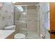 Full bathroom with a single sink vanity, toilet, patterned wallpaper and glass enclosed tiled shower at 360 Pineview St, Altamonte Springs, FL 32701